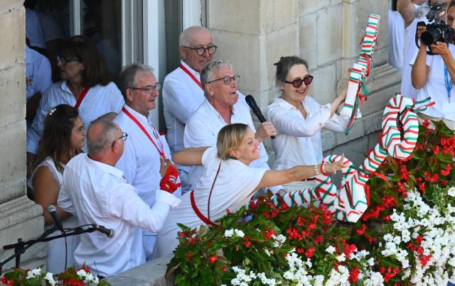 French TV host Maya Lauque (C) takes part in the traditional throwing of the symbolic "keys to the city" from the Town Hall balcony during the opening ceremony of the "Fetes de Bayonne" (Bayonne Festival) in Bayonne, south-western France on July 15, 2026. The Bayonne Festival runs from July 15 to July 19, 2026. (Photo by Gaizka IROZ / AFP)
