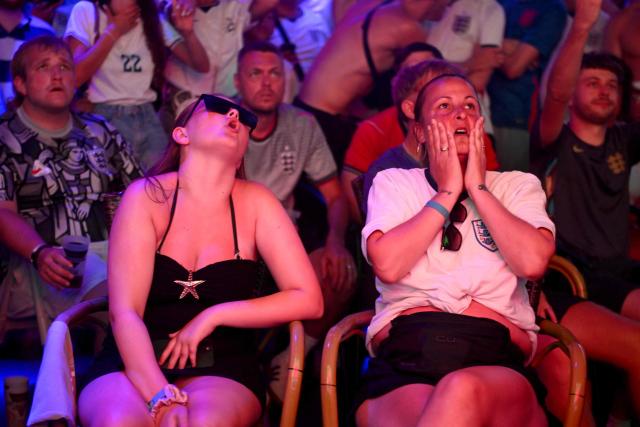 England's supporters react as they watch the 2026 World Cup semi-final football match between England and Argentina in a bar in Benidorm, on Spain's eastern coast, on July 15, 2026. (Photo by JOSE JORDAN / AFP)