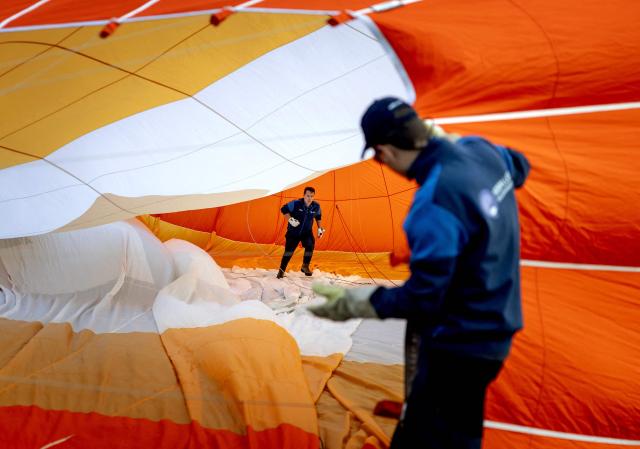 Participants inflate hot air balloons during the 40th edition of the Frisian Balloon Festival in Joure, northern Netherlands on July 15, 2026. (Photo by Koen van Weel / ANP / AFP) / Netherlands OUT