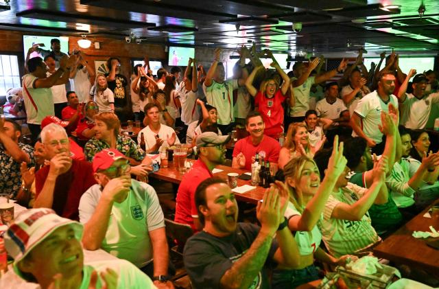 England fans cheer and gesture while watching the 2026 World Cup semi-final match between England and Argentina at the Underground Pub & Grill in Hermosa Beach, California, on July 15, 2026. (Photo by Patrick T. Fallon / AFP)
