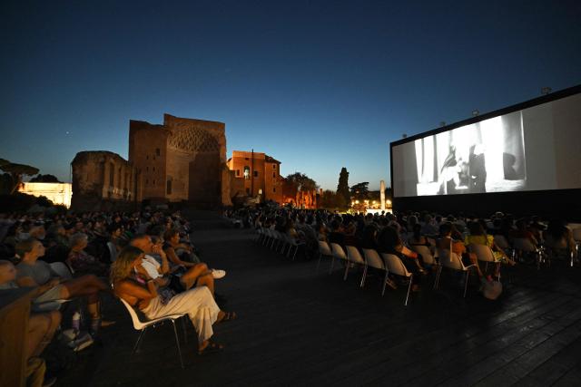 Attendees watch a film during the summer edition of Cinema Festival "QUO VADIS?", at Temple of Venus, the ancient Roman Forum, near the ancient Colosseum, in Rome on July 15, 2026. (Photo by Andreas SOLARO / AFP)