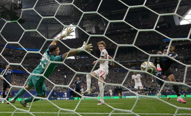 England's forward #18 Anthony Gordon scores his team's first goal past Argentina's goalkeeper #23 Emiliano Martinez during the 2026 World Cup football tournament semi-final match between England and Argentina at the Atlanta Stadium in Atlanta on July 15, 2026.  (Photo by JUAN MABROMATA / AFP)