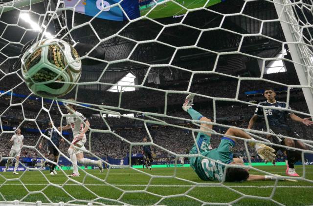 England's forward #18 Anthony Gordon scores his team's first goal past Argentina's goalkeeper #23 Emiliano Martinez during the 2026 World Cup football tournament semi-final match between England and Argentina at the Atlanta Stadium in Atlanta on July 15, 2026.  (Photo by JUAN MABROMATA / AFP)