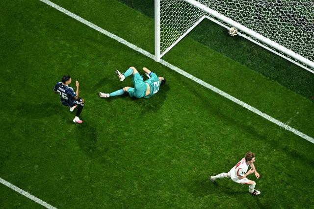 England's forward #18 Anthony Gordon (R) celebrates scoring his team's first goal past Argentina's goalkeeper #23 Emiliano Martinez during the 2026 World Cup football tournament semi-final match between England and Argentina at the Atlanta Stadium in Atlanta on July 15, 2026.  (Photo by Jewel SAMAD / AFP)