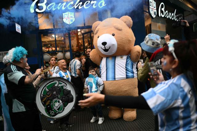 Argentina fans step outside a restaurant to cheer for their team during half-time of the 2026 FIFA World Cup semi-final football match between England and Argentina in Buenos Aires on July 15, 2026. (Photo by Luis ROBAYO / AFP)