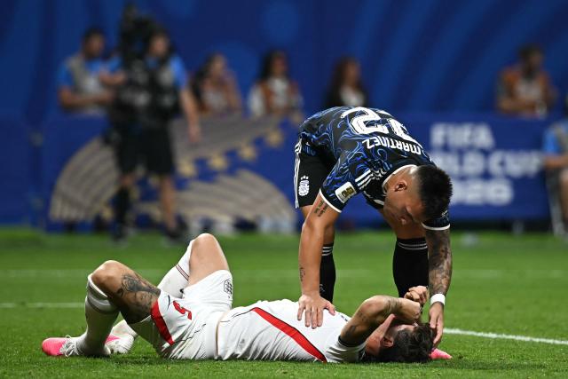 Argentina's forward #22 Lautaro Martinez (top) speaks to England's defender #05 John Stones lying on the pitch during the 2026 World Cup football tournament semi-final match between England and Argentina at the Atlanta Stadium in Atlanta on July 15, 2026.  (Photo by Paul ELLIS / AFP)