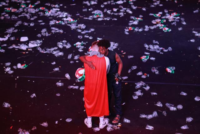 England supporters embrace as others have cleared out after watching a live broadcast of the 2026 World Cup semifinal football match between England and Argentina, at Boxpark Wembley in London on July 15, 2026. (Photo by Brook Mitchell / AFP)