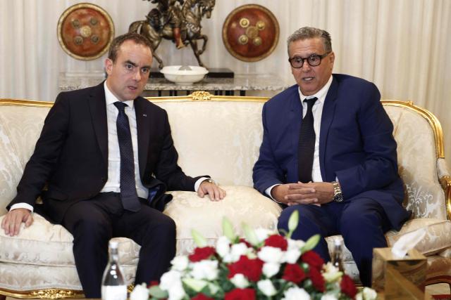 French Prime Minister Sébastien Lecornu (L) speaks to Moroccan Prime Minister Aziz Akhannouch upon his arrival at Rabat-Salé Airport in Rabat on July 15, 2026. (Photo by Abdel Majid BZIOUAT / AFP)