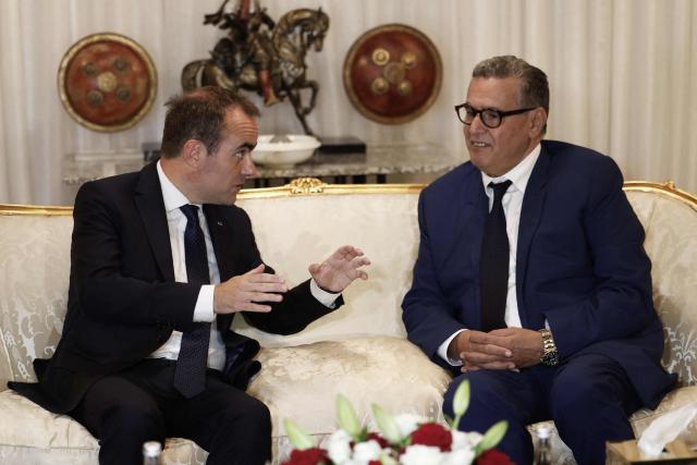 French Prime Minister Sébastien Lecornu (L) speaks to Moroccan Prime Minister Aziz Akhannouch upon his arrival at Rabat-Salé Airport in Rabat on July 15, 2026. (Photo by Abdel Majid BZIOUAT / AFP)