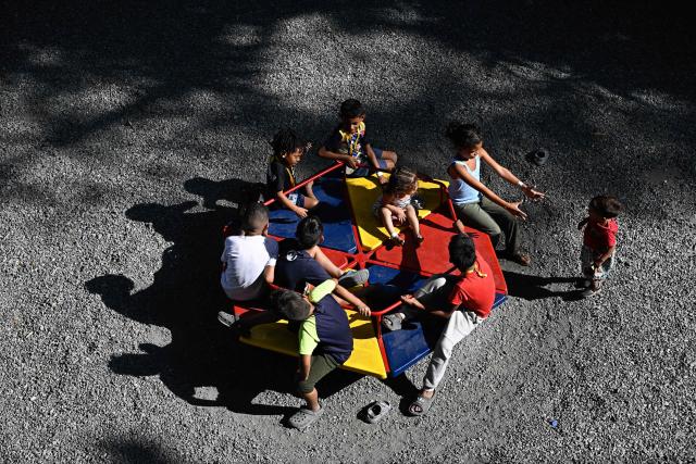 Children displaced from La Guaira play in a playground area at a temporary shelter camp at the Jose Gervasio Artigas Educational Complex in Propatria, Caracas, on July 15, 2026, following the June 24 twin earthquakes. The death toll from the earthquakes that struck Venezuela almost three weeks ago has surpassed 4,700, while almost 17,000 people have been injured, an official report released on July 14, 2026 stated. (Photo by Federico PARRA / AFP)