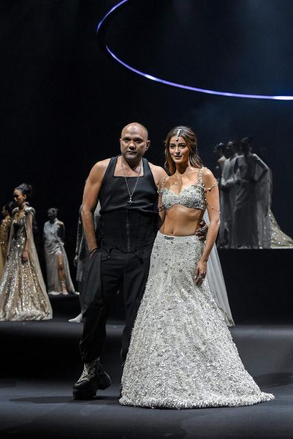 Bollywood actress Ananya Panday (R) presents a creation by Indian designer Gaurav Gupta (L) during the couture show in Mumbai on July 17, 2026. (Photo by Sujit JAISWAL / AFP)