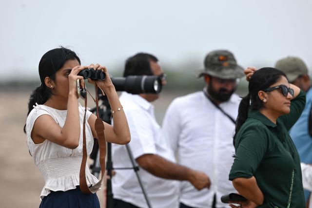 People gathered at Pulicat Lake to witness the launch of India's Skyroot Aerospace orbital rocket Vikram-1 from the Satish Dhawan Space Centre in Andhra Pradesh's Sriharikota on July 18, 2026. (Photo by R.Satish BABU / AFP)