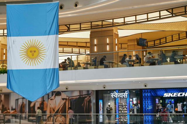 Shoppers are seen next to the Argentine national flag at the Sky City mall in Mumbai on July 18, 2026 on the eve of the 2026 FIFA World Cup football tournament final match between Spain and Argentina. (Photo by Indranil MUKHERJEE / AFP)