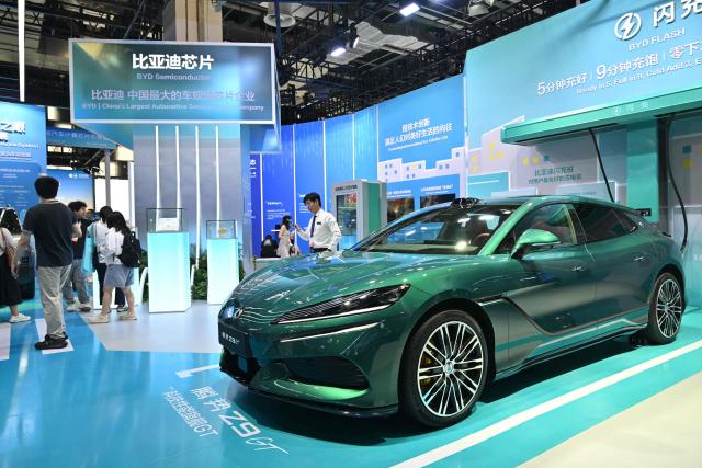 People visit the BYD booth during the World Artificial Intelligence Conference (WAIC) in Shanghai on July 18, 2026. (Photo by Hector RETAMAL / AFP)