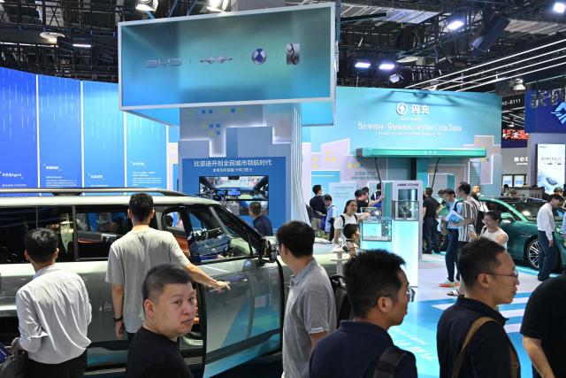 People visit the BYD booth during the World Artificial Intelligence Conference (WAIC) in Shanghai on July 18, 2026. (Photo by Hector RETAMAL / AFP)