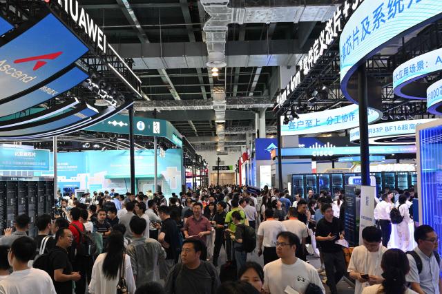 People visit the World Artificial Intelligence Conference (WAIC) in Shanghai on July 18, 2026. (Photo by Hector RETAMAL / AFP)