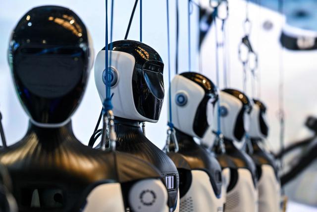 Humanoid robots by OpenMind Robotics are seen during the World Artificial Intelligence Conference (WAIC) in Shanghai on July 18, 2026. (Photo by Hector RETAMAL / AFP)