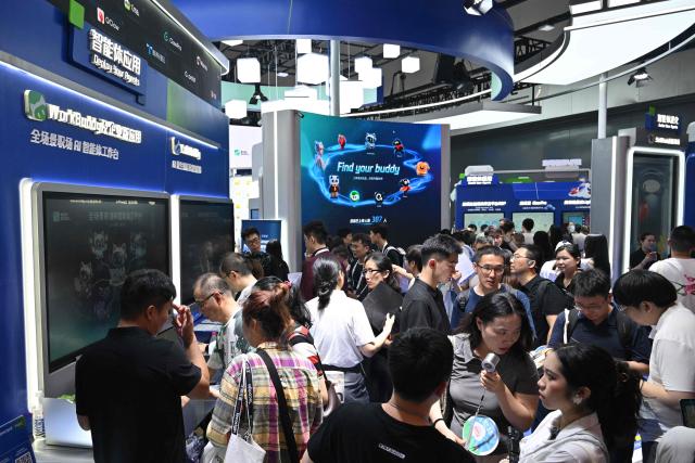 People visit the Tencent booth during the World Artificial Intelligence Conference (WAIC) in Shanghai on July 18, 2026. (Photo by Hector RETAMAL / AFP)