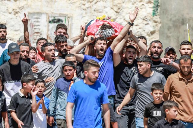 EDITORS NOTE: Graphic content / Mourners carry the body of 17-year-old Fadi al-Naasan during his funeral in the village of Al-Mughayyir, east of Ramallah in the Israeli-occupied West Bank, on July 18, 2026, after he died from wounds sustained about a week ago during clashes with Israeli forces. The occupied West Bank has been gripped by almost daily violence involving Israeli troops and settlers since the start of the Gaza war in October 2023. (Photo by Jaafar ASHTIYEH / AFP)