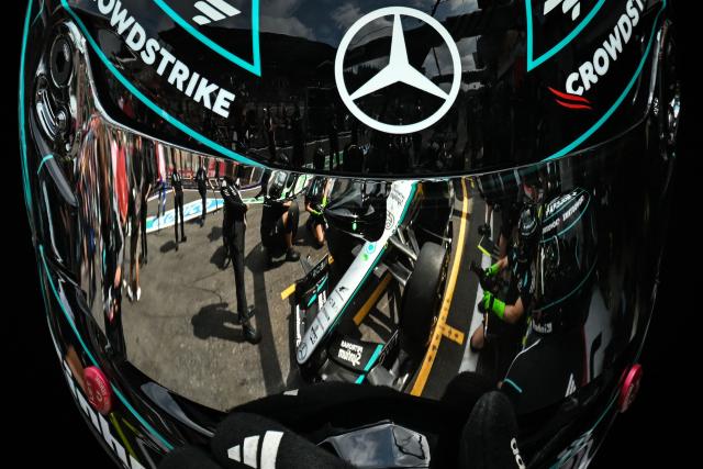 A photograph taken on July 18, 2026 shows Mercedes' team mechanics, reflected on the visor of one of their colleague helmet, as they train for the change of tires on a racing car during the third practice session at the Spa-Francorchamps circuit, in Spa, ahead of the Formula One Belgian Grand Prix, on July 18, 2026. (Photo by Andrej ISAKOVIC / AFP)