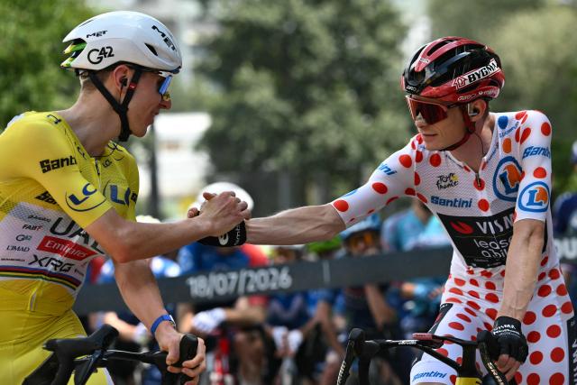 UAE Team Emirates - XRG's Slovenian rider Tadej Pogacar wearing the overall leader's yellow jersey (L) speaks with Team Visma | Lease a Bike's Danish rider Jonas Vingegaard wearing the climber's dotted "King of the Mountains" jersey at the start of the 14th stage of the 113th edition of the Tour de France cycling race, 155,3 km between Mulhouse and Le Markstein in the Vosges mountains, on July 18, 2026. (Photo by Jeff PACHOUD / AFP)
