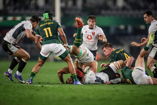 South Africa's lock Ruben van Heerden (C-L) falls face down as he tackles Wales' flanker James Botham (C-R) during the rugby Nations Championship match between South Africa and Wales at Kings Park Stadium in Durban on July 18, 2026. (Photo by PHILL MAGAKOE / AFP)