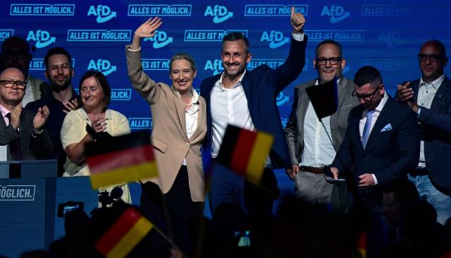 Alice Weidel (C, L), co-leader of the far-right Alternative for Germany (AfD) party, and Ulrich Siegmund (C, R), AfD top candidate for Saxony-Anhalt wave to supportes on stage togehter with other members of the party leadership at the end of an election campaign event ahead of the state elections in Saxony-Anhalt, in Magdeburg, eastern Germany on July 18, 2026. Slogan reads "Everything is possible". The crucial state election in the German eastern federal state of Saxony-Anhalt is scheduled to take place on September 6, 2026. (Photo by John MACDOUGALL / AFP)