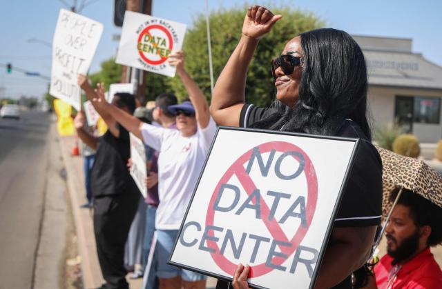 Demonstrators wave signs during a nationwide protest against AI data center expansion in Imperial, California on July 18, 2026. (Photo by SANDY HUFFAKER / AFP)