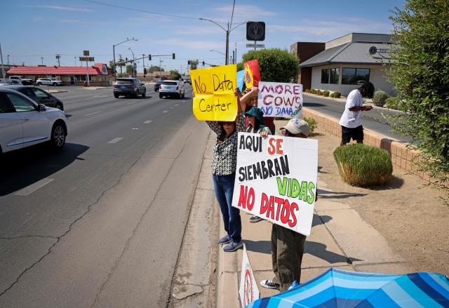 Demonstrators wave signs during a nationwide protest against AI data center expansion in Imperial, California on July 18, 2026. (Photo by SANDY HUFFAKER / AFP)