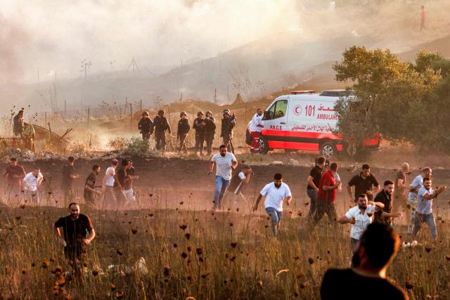 Israeli soldiers disperse with tear gas Palestinians who had gathered as a fire blazes near the village of Tell, adjacent to the Israeli settlement of Havat Gilad, west of Nablus in the occupied West Bank on July 18, 2026, after a reported arson attack by Israeli settlers on the village, according to eyewitnesses. (Photo by Jaafar ASHTIYEH / AFP)