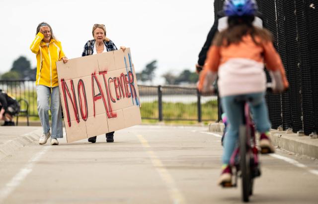 People hold up signs on a pedestrian bridge during a nationwide protest against AI data center expansion in Berkeley, California on July 18, 2026. (Photo by Josh Edelson / AFP)