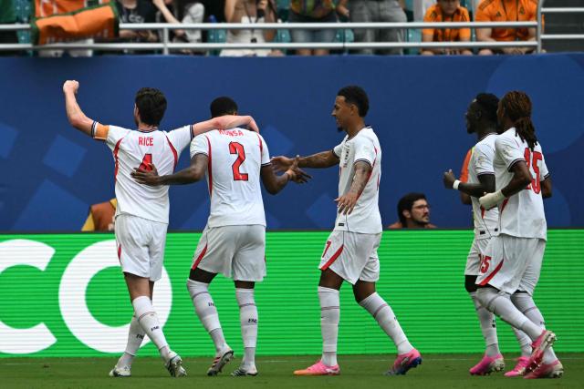 England's defender #02 Ezri Konsa celebrates scoring his team's second goal with teammates during the 2026 World Cup football tournament third-place match between France and England at the Miami Stadium in Miami on July 18, 2026.  (Photo by ROBERTO SCHMIDT / AFP)