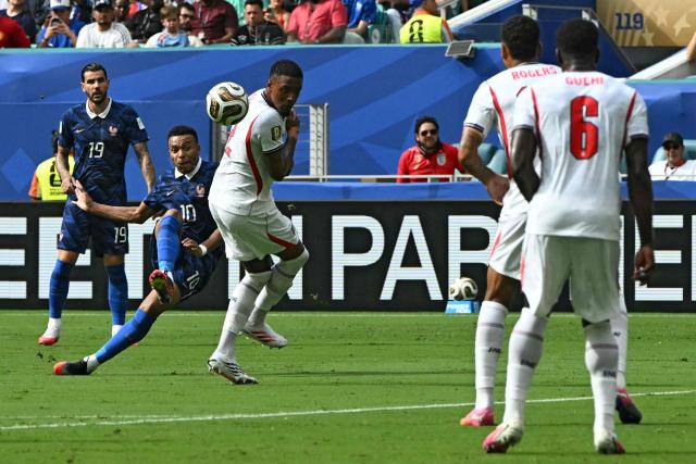 France's forward #10 Kylian Mbappe kicks the ball past England's defender #02 Ezri Konsa during the 2026 World Cup football tournament third-place match between France and England at the Miami Stadium in Miami on July 18, 2026.  (Photo by ROBERTO SCHMIDT / AFP)