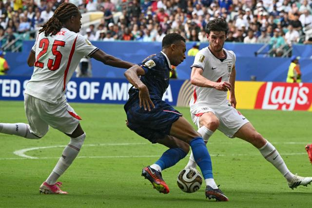 France's forward #10 Kylian Mbappe (C) fights for the ball with England's midfielder #04 Declan Rice (R) and defender #25 Djed Spence (L) during the 2026 World Cup football tournament third-place match between France and England at the Miami Stadium in Miami on July 18, 2026.  (Photo by ROBERTO SCHMIDT / AFP)