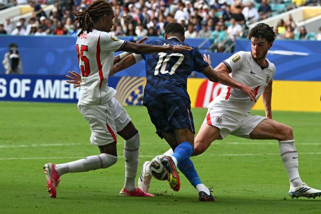 France's forward #10 Kylian Mbappe (C) fights for the ball with England's midfielder #04 Declan Rice (R) and defender #25 Djed Spence (L) during the 2026 World Cup football tournament third-place match between France and England at the Miami Stadium in Miami on July 18, 2026.  (Photo by ROBERTO SCHMIDT / AFP)