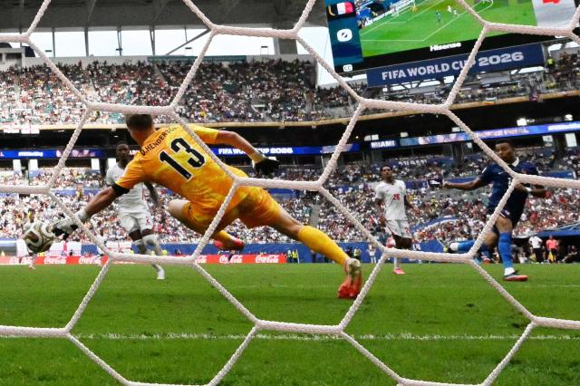 England's goalkeeper #13 Dean Henderson concedes a goal scored by France's forward #10 Kylian Mbappe and his team's first goal during the 2026 World Cup football tournament third-place match between France and England at the Miami Stadium in Miami on July 18, 2026.  (Photo by CHANDAN KHANNA / AFP)
