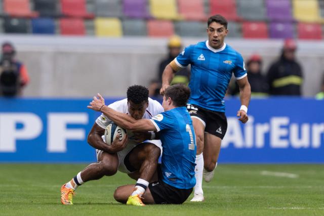 England's wing Immanuel Feyi-Waboso (L) is tackled by Argentina's wing Bautista Delguy during the Rugby Union Nations Championship match between Argentina and England at Unico Madre de Ciudades stadium in Santiago del Estero, Argentina, on July 18, 2026. Argentina players wear a blue jersey as a tribute to the Argentina national football team that defeated England with goals by Diego Maradona at the Mexico 1986 World Cup. (Photo by Juan GASPARINI / AFP)