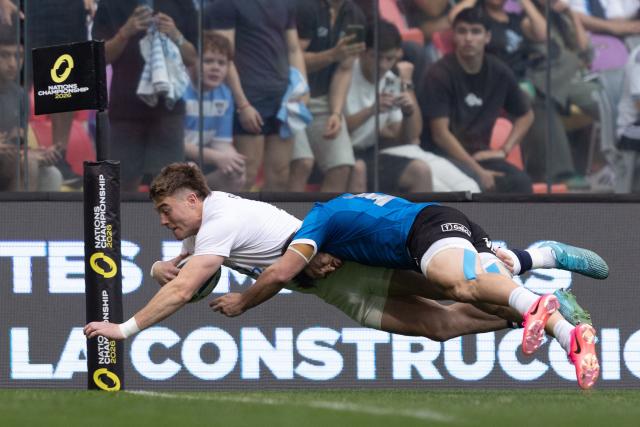 England's wing Tommy Freeman scores a try tackled by Argentina's wing Mateo Carreras during the Rugby Union Nations Championship match between Argentina and England at Unico Madre de Ciudades stadium in Santiago del Estero, Argentina, on July 18, 2026. Argentina players wear a blue jersey as a tribute to the Argentina national football team that defeated England with goals by Diego Maradona at the Mexico 1986 World Cup. (Photo by Juan GASPARINI / AFP)