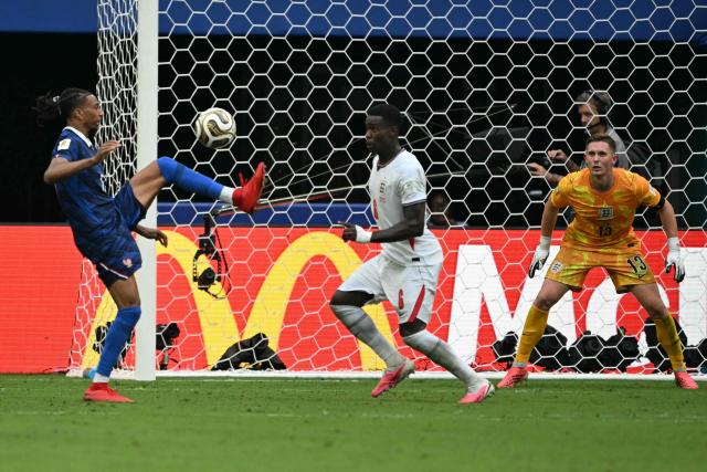 France's forward #11 Michael Olise (L) controls the ball past England's defender #06 Marc Guehi and goalkeeper #13 Dean Henderson during the 2026 World Cup football tournament third-place match between France and England at the Miami Stadium in Miami on July 18, 2026.  (Photo by ROBERTO SCHMIDT / AFP)
