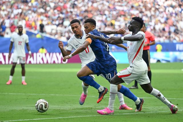 TOPSHOT - England's midfielder #17 Morgan Rogers and England's forward #07 Bukayo Saka fight for the ball with France's forward #10 Kylian Mbappe during the 2026 World Cup football tournament third-place match between France and England at the Miami Stadium in Miami on July 18, 2026.  (Photo by CHANDAN KHANNA / AFP)