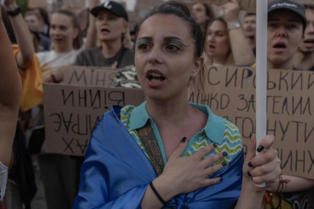 A protester sings the Ukrainian national anthem during a demonstration against Ukraine's President's decision to dismiss Ukraine's Defence Minister Mykhailo Fedorov, and demanding the dismissal of Ukraine's army chief Oleksandr Syrskyi, in Kyiv on July 18, 2026, amid the Russian invasion of Ukraine. Large protests erupted in several Ukrainian cities against the removal of popular Defence Minister Fedorov, who had been brought in six months ago to digitise and modernise an army fatigued after four years fighting off the Russian invasion. (Photo by Roman PILIPEY / AFP)