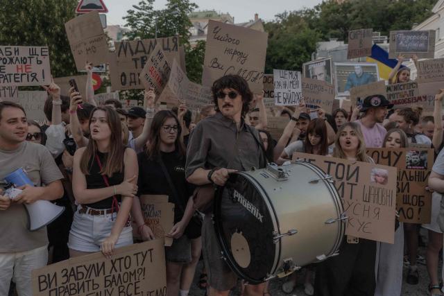 Protesters hold placards and chant slogans during a demonstration against Ukraine's President's decision to dismiss Ukraine's Defence Minister Mykhailo Fedorov, and demanding the dismissal of Ukraine's army chief Oleksandr Syrskyi, in Kyiv on July 18, 2026, amid the Russian invasion of Ukraine. Large protests erupted in several Ukrainian cities against the removal of popular Defence Minister Fedorov, who had been brought in six months ago to digitise and modernise an army fatigued after four years fighting off the Russian invasion. (Photo by Roman PILIPEY / AFP)