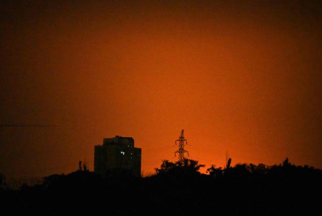 This photograph shows glow during Russian missile strikes on the Ukrainian capital of Kyiv on July 19, 2026, amid the Russian invasion in Ukraine. Russian missiles rocked Ukraine's capital overnight, killing at least one person and wounding five others day after Kyiv launched a deadly wave of drones that pounded e-commerce warehouses in Russia. (Photo by Sergei SUPINSKY / AFP)