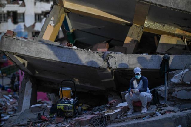 A woman sitsamid debris of buildings damaged by the June 24 earthquakes, in Tanaguarena, state of La Guaira; Venezuela, on July 18, 2026. The twin earthquakes that struck Venezuela last month killed over 5,000 people, officials said, while announcing they drew hundreds of millions of dollars from the International Monetary Fund (IMF) for reconstruction. (Photo by Juan BARRETO / AFP)