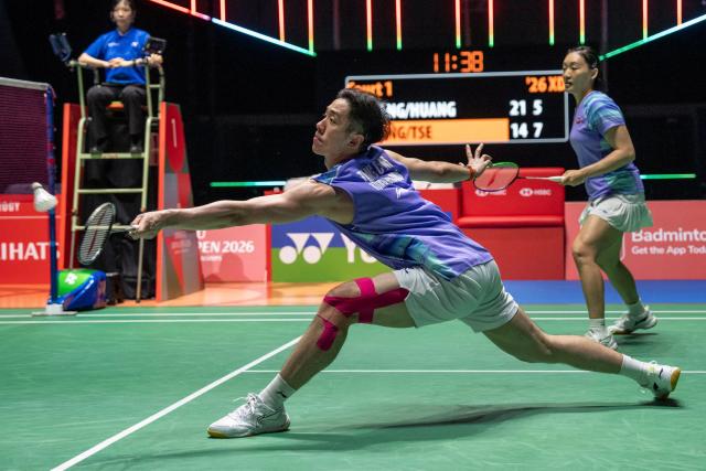 Hong Kong's Tang Chun Man (L) and Tse Ying Suet (R) hit a return against China’s Feng Yanzhe and Huang Dongping in their mixed doubles final match of the Japan Open badminton tournament at Tokyo Gymnasium in Tokyo on July 19, 2026. (Photo by Yuichi YAMAZAKI / AFP)