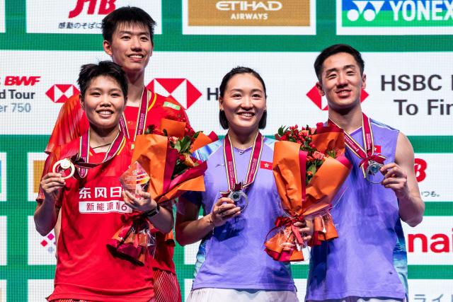 Gold medalists China’s Feng Yanzhe (2nd L) and Huang Dongping (L) and silver medalists Hong Kong's Tang Chun Man and Tse Ying Suet pose on the podium after their mixed doubles final match of the Japan Open badminton tournament at Tokyo Gymnasium in Tokyo on July 19, 2026. (Photo by Yuichi YAMAZAKI / AFP)