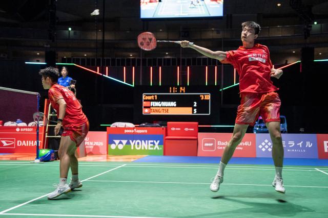 China’s Feng Yanzhe (R) and Huang Dongping hit a return against Hong Kong's Tang Chun Man and Tse Ying Suet in their mixed doubles final match of the Japan Open badminton tournament at Tokyo Gymnasium in Tokyo on July 19, 2026. (Photo by Yuichi YAMAZAKI / AFP)