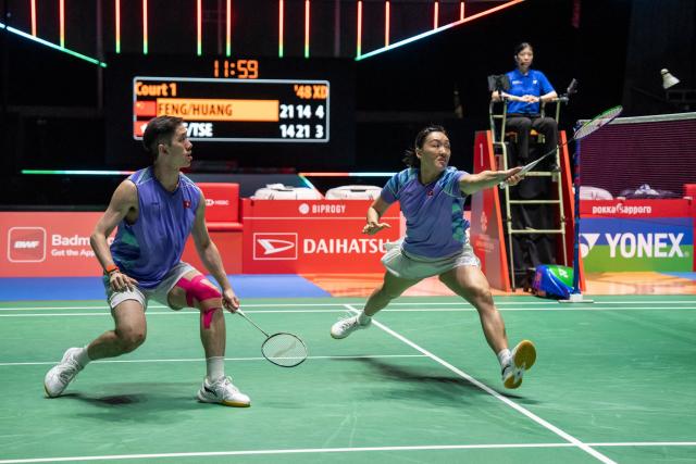 Hong Kong's Tse Ying Suet (R) and Tang Chun Man (L) hit a return against China’s Feng Yanzhe and Huang Dongping in their mixed doubles final match of the Japan Open badminton tournament at Tokyo Gymnasium in Tokyo on July 19, 2026. (Photo by Yuichi YAMAZAKI / AFP)