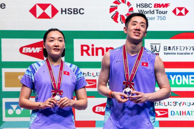 Silver medalists Hong Kong's Tang Chun Man (R) and Tse Ying Suet (L) pose on the podium after their mixed doubles final match against China’s Feng Yanzhe and Huang Dongping in the Japan Open badminton tournament at Tokyo Gymnasium in Tokyo on July 19, 2026. (Photo by Yuichi YAMAZAKI / AFP)
