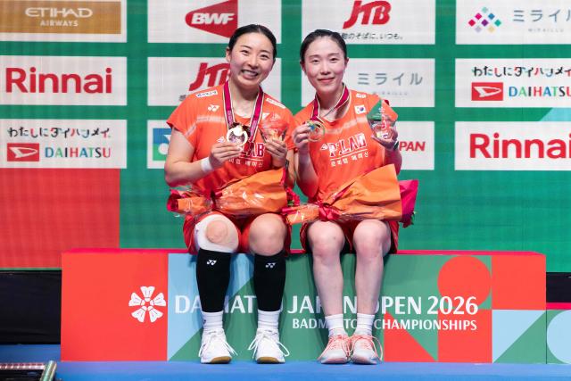 Gold medallists South Korea’s Kim Hye-jeong (R) and Kong Hee-yong pose on the podium after their victory against  China’s Jia Yifan and Zhang Shuxian during the women's doubles final of the Japan Open badminton tournament at Tokyo Gymnasium in Tokyo on July 19, 2026. (Photo by Yuichi YAMAZAKI / AFP)
